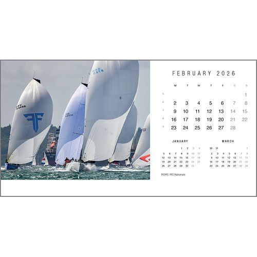 The Rick Tomlinson Desk Calendar 2026 by Rick Tomlinson Photography features a striking February yachting photo of sailboats racing, with smaller January and March sailing images also visible on the desk calendar page.