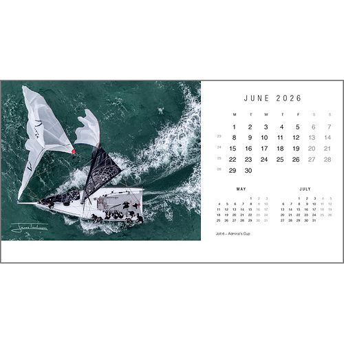 A striking aerial of a sailboat on green waters highlights the June 2026 page of the Rick Tomlinson Desk Calendar from Rick Tomlinson Photography, with small calendars for May and July and iconic yachting photography throughout.