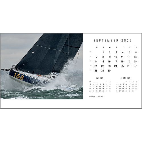 A sailboat numbered 168 speeds through choppy waves next to a September 2026 Rick Tomlinson Desk Calendar by Rick Tomlinson Photography, with August and October calendars shown below, capturing the dynamic spirit of yachting.