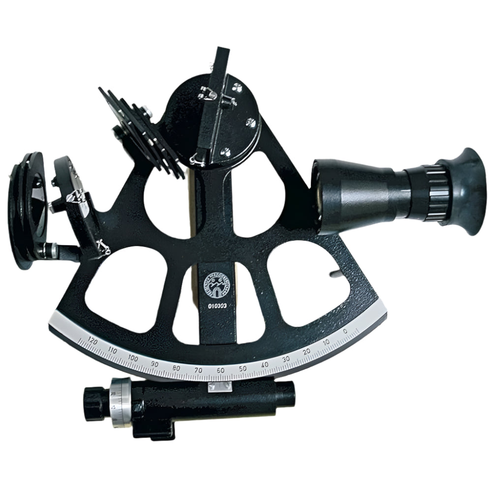 The Freiberger Präzisionsmechanik Freiberger Drum Sextant is a black metal instrument with a curved scale, mirrors, adjustable dials, and a telescope attachment for precise celestial navigation at sea.