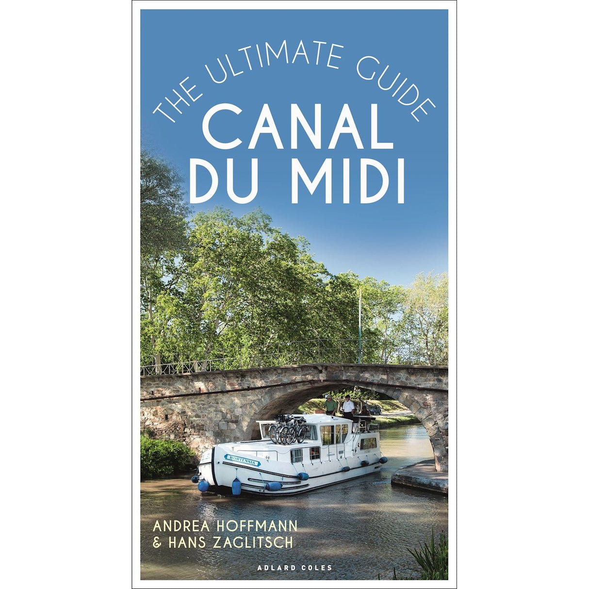 Cover of "Canal du Midi" by Andrea Hoffmann & Hans Zaglitsch features a scenic boat under a stone bridge on the UNESCO World Heritage canal, bordered by lush trees. Published by Adlard Coles, it's ideal for boating holiday planners.