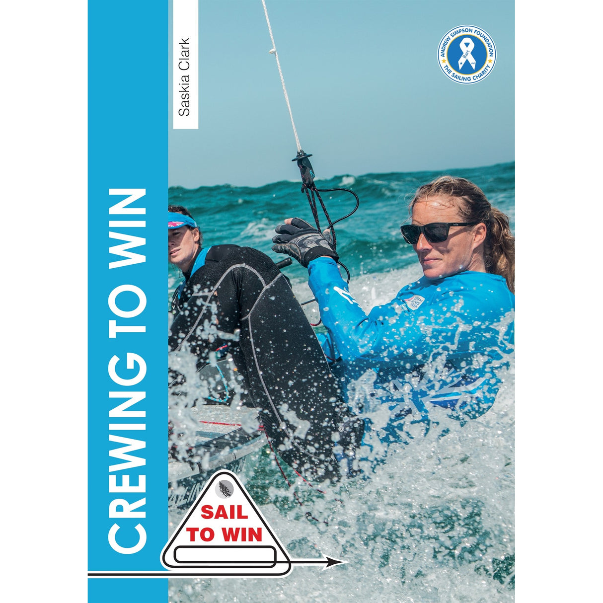 Two women sail in choppy waters, both in blue jackets and sunglasses, showing Olympic crew teamwork. One holds a rope and leans over the side. Text: "CREWING TO WIN"—Crewing To Win by Fernhurst Books. "SAIL TO WIN.