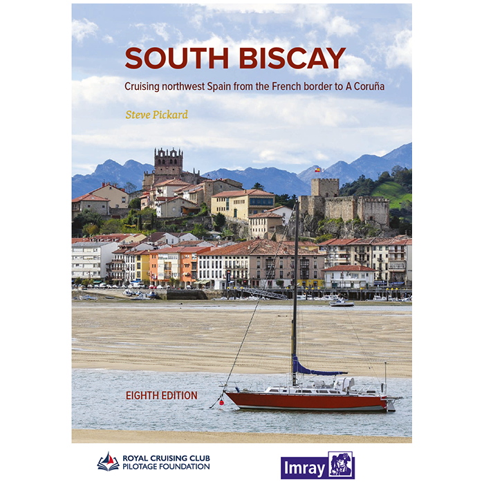 The cover of Imray's "South Biscay" Yachting Guide depicts a coastal town with colorful buildings and a historic fort, set against majestic mountains. A sailboat is anchored in calm waters in the foreground. This is the eighth edition, featuring logos at the bottom.