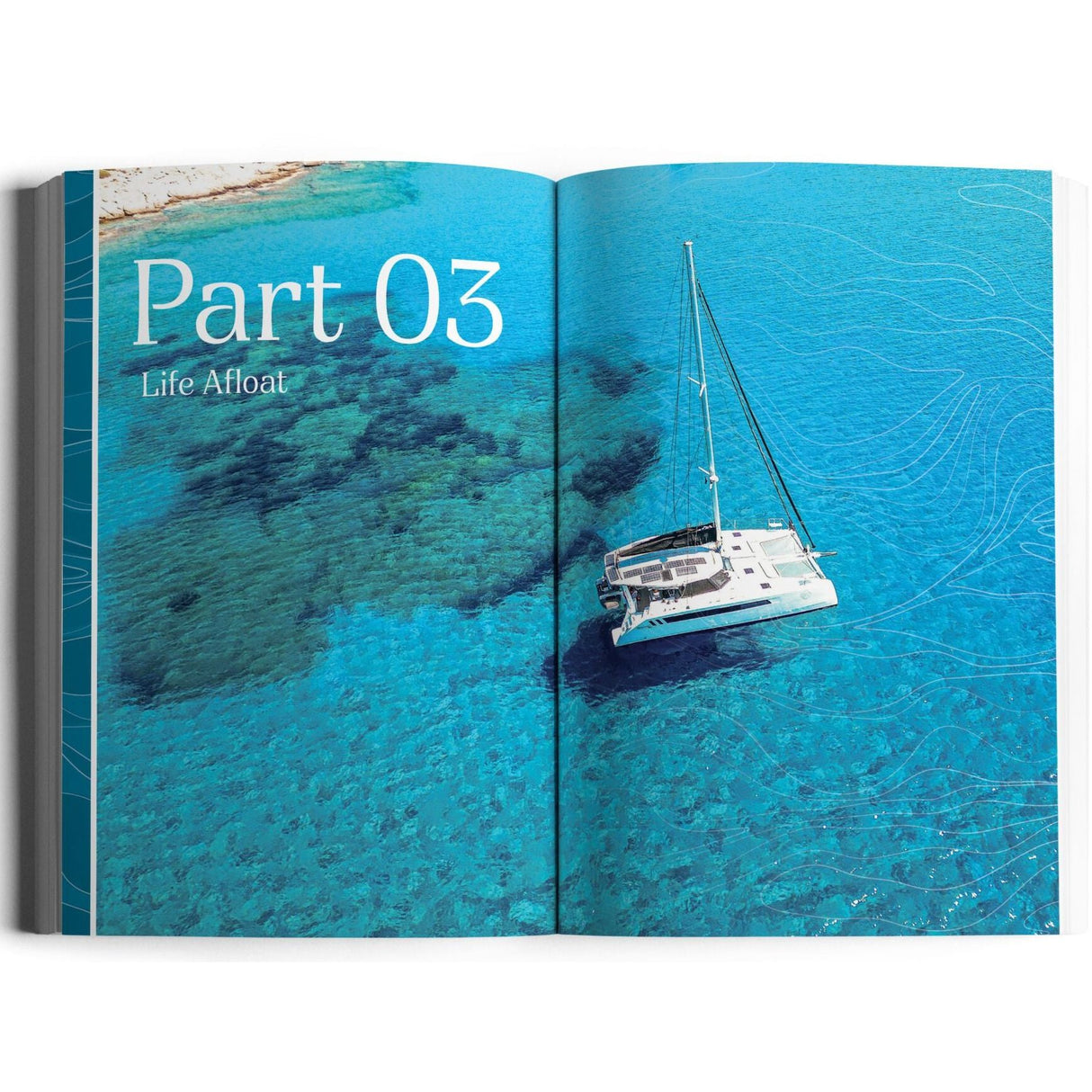 An open book shows an aerial view of a white catamaran on turquoise water near the coast. The text says “Part 03: Life Afloat.” It’s The Boat Life Manual by Exploring Eden Media, capturing the spirit of liveaboard cruising.