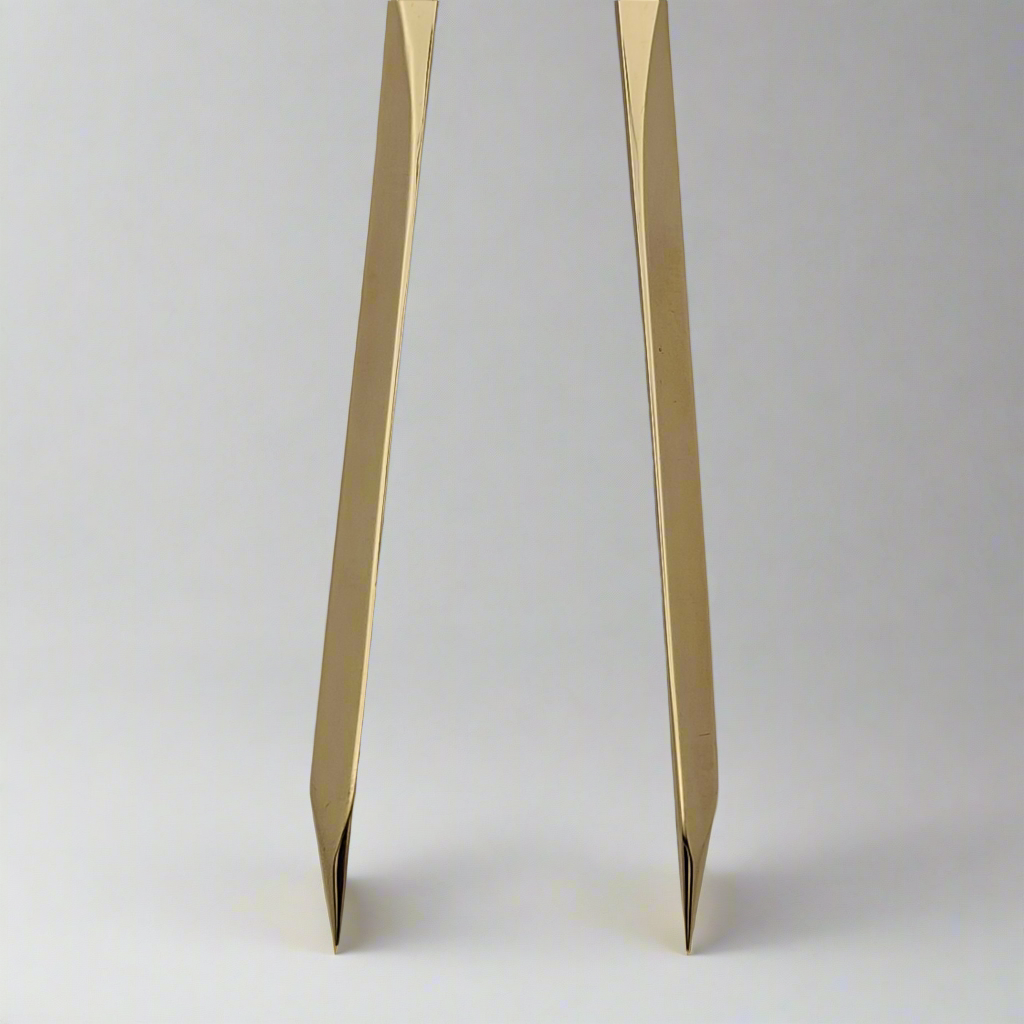 Close-up of the pointed ends of the Chartwright 8" Straight Brass Dividers against a plain, light background. The tips are sharp and angled, extending downward slightly apart from each other, showcasing this precision instrument's craftsmanship from Chartwright.