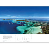 An aerial view of the San Blas Islands captures the breathtaking turquoise waters, coral reefs, and anchored sailboats, highlighting stunning sailing photography. At the bottom sits a February 2025 page from the Rick Tomlinson Portfolio Calendar 2025 by Rick Tomlinson Photography, complete with the photographer's signature.