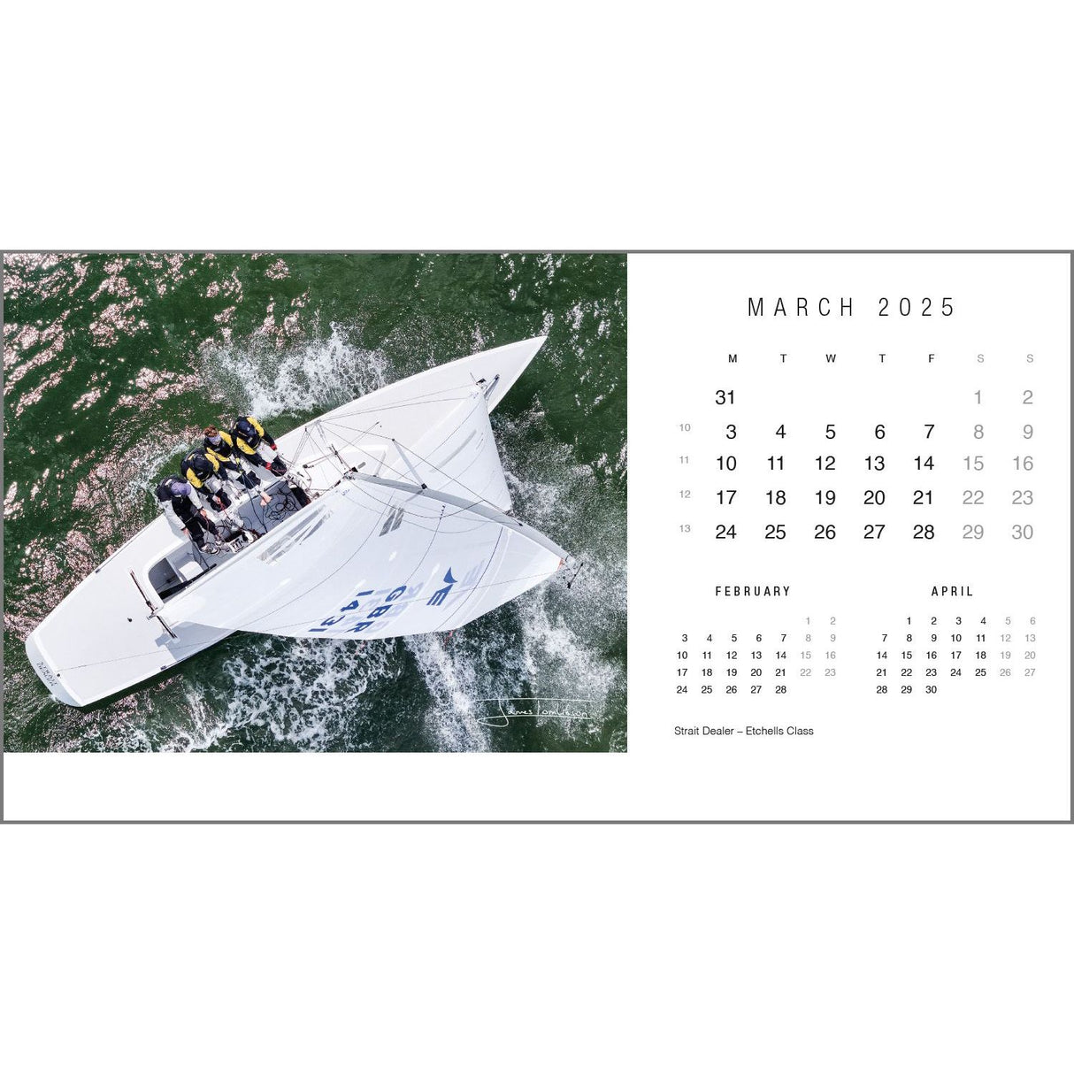 Aerial view of a sailing boat with a group of people onboard navigating through green waters, photographed by the renowned yachting photographer Rick Tomlinson. The Rick Tomlinson Desk Calendar 2025 is open to March, offering glimpses of February and April dates, much like a classic sailing desk calendar from Rick Tomlinson Photography.