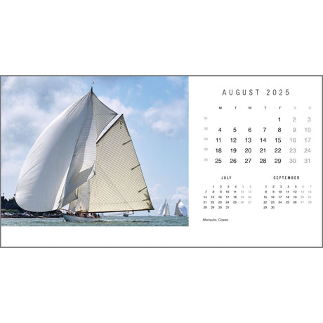 A sailboat with white sails glides across the water under a blue sky. On the right, a Rick Tomlinson Desk Calendar 2025 from Rick Tomlinson Photography is displayed, highlighting weekends in bold and evoking the yachting captures by Rick Tomlinson.