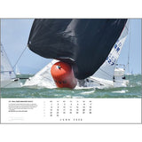 A dramatic sailing photo of two boats racing around an orange buoy on choppy water with a dark sail is featured as the June 2026 page in the Rick Tomlinson Portfolio Calendar 2026 by Rick Tomlinson Photography.