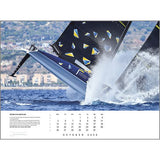 A sailboat speeds through choppy blue water with splashing waves on the Rick Tomlinson Portfolio Calendar 2026 by Rick Tomlinson Photography, featuring October’s dates and text visible at the bottom.