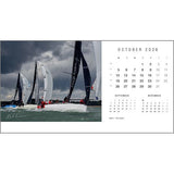 The Rick Tomlinson Desk Calendar 2026 by Rick Tomlinson Photography features October’s page with stunning sailboats racing under a cloudy sky, plus mini calendars for September and November below the main month.