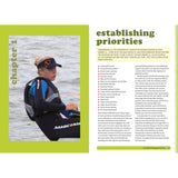 A person in a cap and jacket is seated in a small boat, looking left. The page features "Winning Isn't Luck" by Bloomsbury with sections on establishing priorities in competitive sailing, including goals, settings, and self-check questions for sailing success.