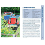 Colorful narrowboats line Basingstoke Canal amid greenery and yellow blooms. The Nicholson Waterways Guide 7: River Thames and the Southern Waterways by Nicholson provides detailed info on canal dimensions, history, and navigation rules.