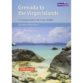 The cover of Imray's "Grenada to the Virgin Islands," a quintessential Caribbean travel guide, showcases a scenic coastal view with turquoise waters, rocky shores, sailboats, and distant islands under a partly cloudy sky. This is its third edition.