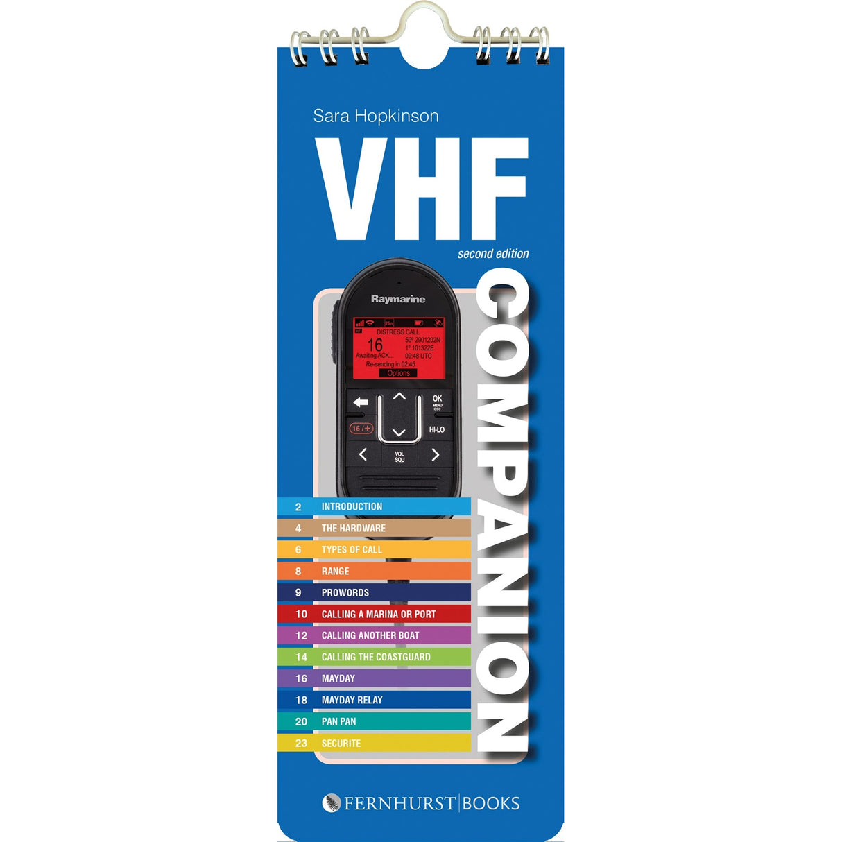 The "VHF Companion" by Fernhurst Books is a spiral-bound guidebook with a VHF radio cover and colorful numbered contents, serving as an essential reference for radio call and DSC procedures.