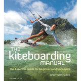 A kiteboarder glides over the ocean with a mountain backdrop under a blue sky, featured on the cover of Adlard Coles' "The Kiteboarding Manual: 2nd Edition," an essential guide for beginners and improvers by Andy Gratwick.