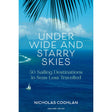 Cover of "Under Wide and Starry Skies" by Adlard Coles, showcasing a tropical sea with a distant sailboat and palm fronds above. Text emphasizes 50 remote anchorages in less-traveled seas.