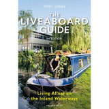 A person stands on a blue canal boat by a peaceful waterway, embracing life afloat. Trees and a modern building are in the background. Text reads: "The Liveaboard Guide" by Tony Jones, from Adlard Coles.