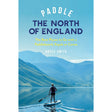 A person paddleboarding on a tranquil lake framed by mountains, capturing the North of England’s spirit, with "Paddle the North of England" by Adlard Coles shown above.