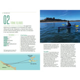 A kayaker glides across blue waters toward a rocky coast crowned by a castle, under clear skies. "Paddle the North of England" by Adlard Coles also covers Northumberland canoeing, the Farne Islands, and visitor tips on the left.