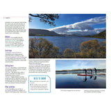 A scenic lake view with tree-covered hills and calm water reflecting the sky. Inset: two people enjoy stand-up paddleboarding, as featured in "Paddle the North of England" by Adlard Coles; a café and local info are also shown.