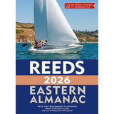 A white sailboat with people sails on blue water near green hills. The cover reads: "Reeds Eastern Almanac 2026" by Reeds, featuring North Sea navigation advice and tide tables for covered regions.