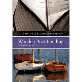 Cover of "Wooden Boatbuilding" by Adlard Coles features a close-up of a boat's hull showing traditional construction. The book title sits on a purple band, with an image below displaying two wooden boats on water with elegant reflections.