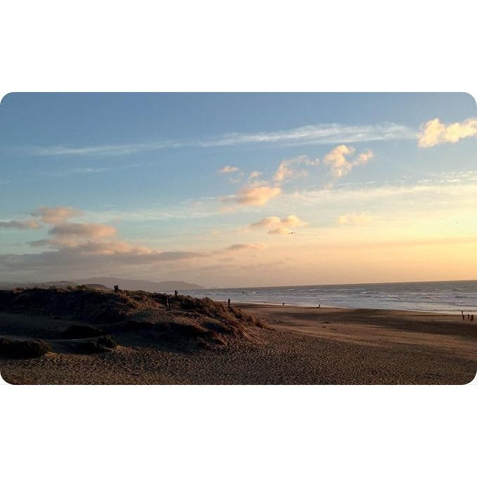 The Cloud Deck beach with sandy dunes under a sunset sky filled with dramatic cloud formations.