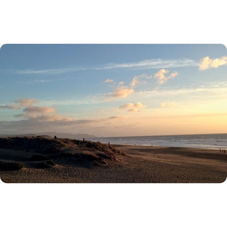 The Cloud Deck beach with sandy dunes under a sunset sky filled with dramatic cloud formations.