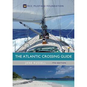Cover of "The Atlantic Crossing Guide" by Adlard Coles features a sailing boat navigating rough Atlantic waves, paired with a serene tropical beach inviting sailors under clear skies.