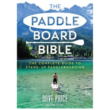 A man embodies paddleboard adventure atop a clear lake surrounded by nature. The book cover states, "The Paddleboard Bible" from Adlard Coles, a complete guide to stand-up paddleboarding by Dave Price.