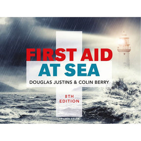The book cover for "First Aid at Sea," 8th Edition by Adlard Coles, depicts a lighthouse against stormy seas, illustrating seafarer challenges. The bold red and blue title emphasizes the critical importance of emergency first aid.