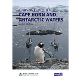 A penguin stands on a rocky shore as two sailboats rest in icy Antarctic waters before snow-capped peaks—a striking cover for Imray’s "Cruising Guide to Cape Horn and Antarctic Waters," with the title and author shown at the top.