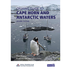A penguin stands on a rocky shore as two sailboats rest in icy Antarctic waters before snow-capped peaks—a striking cover for Imray’s "Cruising Guide to Cape Horn and Antarctic Waters," with the title and author shown at the top.