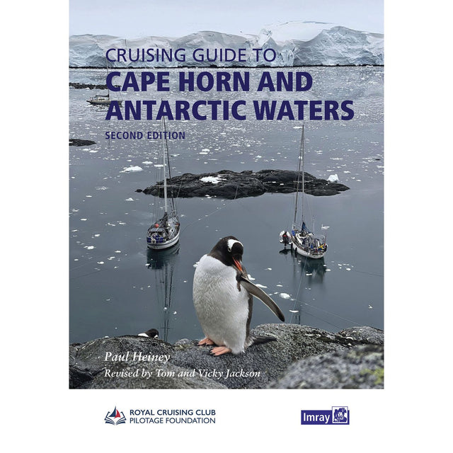 A penguin stands on a rocky shore as two sailboats rest in icy Antarctic waters before snow-capped peaks—a striking cover for Imray’s "Cruising Guide to Cape Horn and Antarctic Waters," with the title and author shown at the top.