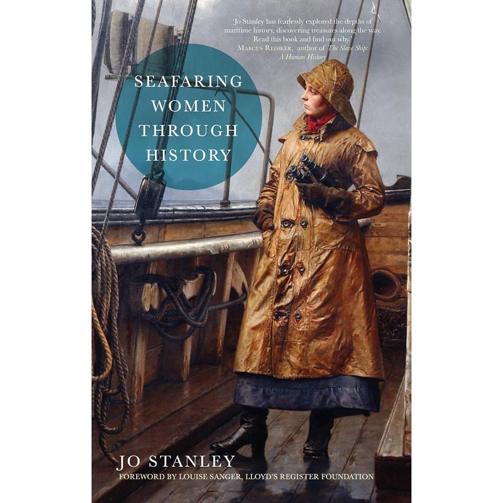A woman in a long coat and rain hat holds binoculars on a ship’s deck, as featured in Seafaring Women Through History.