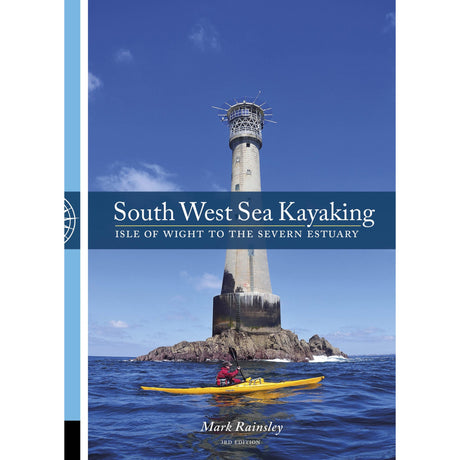 A kayaker in a yellow kayak navigates the sea beside a towering lighthouse set on rocky cliffs, all beneath a clear blue sky. The book "South West Sea Kayaking" by Pesda Press is an essential guide for exploring the most scenic sea kayaking routes from the Isle of Wight to the Severn Estuary along this breathtaking coastline.