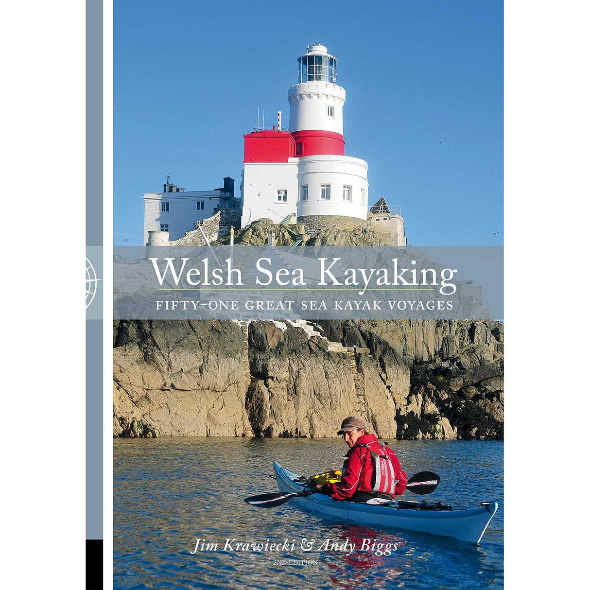 A kayaker paddles along a rocky shoreline beneath a white and red lighthouse under a clear blue sky. Text reads: "Welsh Sea Kayaking" by Pesda Press—your essential guide to 51 great sea kayak voyages for exploring the stunning Welsh coastline.