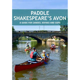 Canoeists, kayakers, and paddleboarders enjoy a tranquil stretch of the river beneath a stone arch bridge, surrounded by lush trees and scenic buildings. The cover of "Paddle Shakespeare's Avon" by Pesda Press features the subtitle: "A guide for canoes, kayaks and SUPs – your essential River Avon paddling guide.
