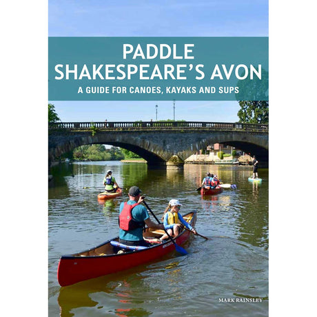 Canoeists, kayakers, and paddleboarders enjoy a tranquil stretch of the river beneath a stone arch bridge, surrounded by lush trees and scenic buildings. The cover of "Paddle Shakespeare's Avon" by Pesda Press features the subtitle: "A guide for canoes, kayaks and SUPs – your essential River Avon paddling guide.
