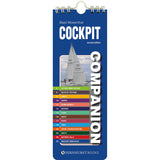 The "Cockpit Companion" by Fernhurst Books is a blue spiral-bound cruising reference booklet, featuring a sailboat and a colorful seamanship index—covering topics like lights, buoys, knots, safety, and distress calls—on its cover.