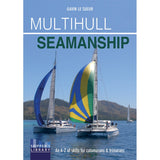 Fernhurst Books’ "Multihull Seamanship" book cover shows two colorful catamarans sailing on blue water with hills behind. Subtitle: “An A-Z of skills for catamaran sailing & trimaran sailing.”.
