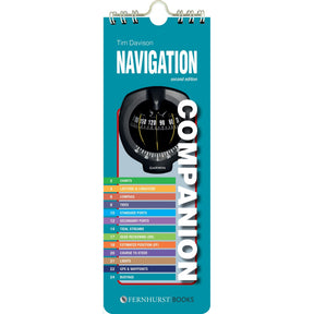Navigation Companion" by Fernhurst Books is a spiral-bound guide with a blue cover featuring a compass image and a colorful topic index for charts, tides, GPS, buoys, and more—ideal for onboard navigation.