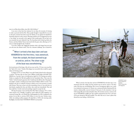 In an industrial dock dusted with snow, two people work on a long sailboat mast amid warehouses and cranes—an image reminiscent of Dick Carter: Yacht Designer by Fernhurst Books.