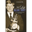 A man in a suit holds a large sailing trophy. The book cover reads: "My Life In A Blue Suit" by Fernhurst Books, telling the story of Olympic sailing coach Jim Saltonstall MBE, who helped make Britain great at sailing.