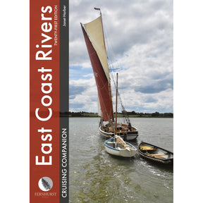 A sailboat with a large reddish-brown mainsail towing two small wooden dinghies on a river, as featured in the East Coast Rivers Cruising Companion by Fernhurst Books.