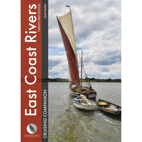 A sailboat with a large reddish-brown mainsail towing two small wooden dinghies on a river, as featured in the East Coast Rivers Cruising Companion by Fernhurst Books.