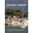 Cover of the book "West Country" by Carlos Rojas and Susan Kemp-Wheeler, from Imray. This vibrant cruising guide features a coastal town with buildings and lush hills in the background, alongside a sailboat in the calm harbor under gray skies.