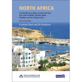 Cover of "North Africa" by Imray, authored by Graham Hutt and Di Stoddard. This cruising guide spans Morocco, Algeria, Tunisia, Libya, Ceuta & Melilla, Gibraltar, Malta, Pantelleria, and the Pelagie Islands. The cover image features a coastal marina lined with boats and buildings near the shore—perfect launching points along the Moroccan coastline.