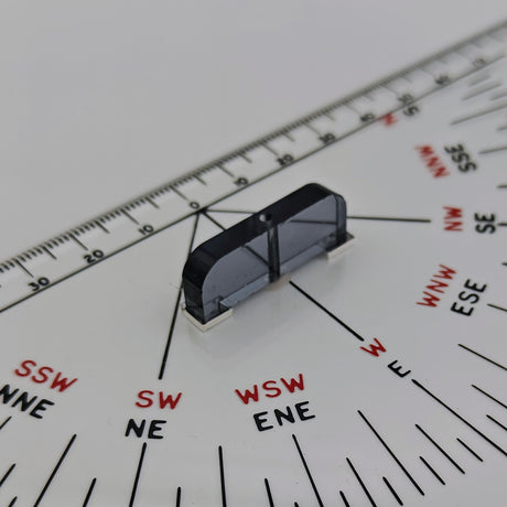 Close-up of a 12" Navigation Triangle by Charles, Smith & Reddish with a black rotating directional indicator positioned over a compass rose. The navigation triangle, showcasing traditional craftsmanship, is marked with degrees along the edges and compass points in black and red, indicating various directions such as SW, WSW, and ENE.